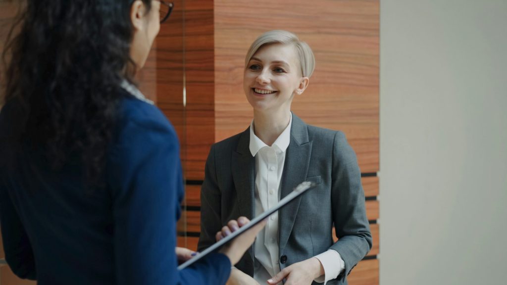 Two women in business attire talking